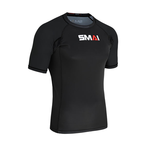 The SMAI Short Sleeve Rash Guard in black features the white and red SMAI logo on the chest, ideal for no-gi BJJ training, shown on a plain white background.