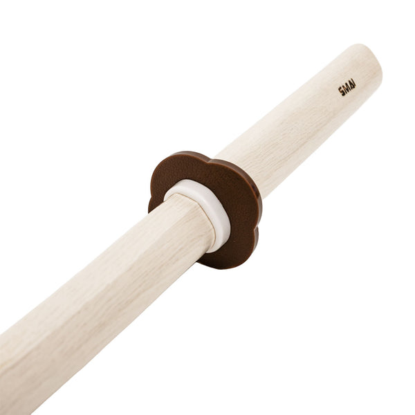 The SMAI Bokken - White Oak Stained Beechwood is a wooden practice sword with a light blade and handle, brown and white flower-shaped guard, and "SAMA" engraving—perfect for martial arts training.