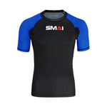 The SMAI Short Sleeve Rash Guard - Blue features a black body, blue sleeves with dark blue trim, and "SMAI" in white and red on the chest—perfect for no-gi grappling or use as a compression shirt.