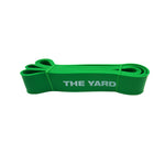The Yard - Exercise Resistance Band by SMAI, 75lb/34kg in green with "THE YARD" in white, is coiled neatly against a white background.