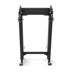 A black Functional Trainer with Dual Cable Stacks from the SMAI Vanta Series stands empty. Designed for weight training, it features adjustable components, multiple holes for barbell placement, and dual cable stacks for versatility. Its sturdy, minimalist frame is compact and functional, making it ideal for home or gym use.
