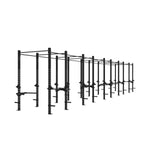 The SMAI Yard - Rig - 10 Squat Cell is a long, black modular freestanding gym rig with multiple squat racks, pull-up bars, and adjustable attachments, designed for versatile commercial gym use and showcased against a white background.