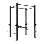 The SMAI The Yard - Rig - 2 Cell is a black metal power rack for weightlifting, designed with multiple holes for adjustable attachments and equipped with a pull-up bar at the top. It features integrated weight plate storage and safety bars, as well as convenient weight plate holders. This freestanding squat rig can also be fitted with optional dip stations, all presented against a white background.