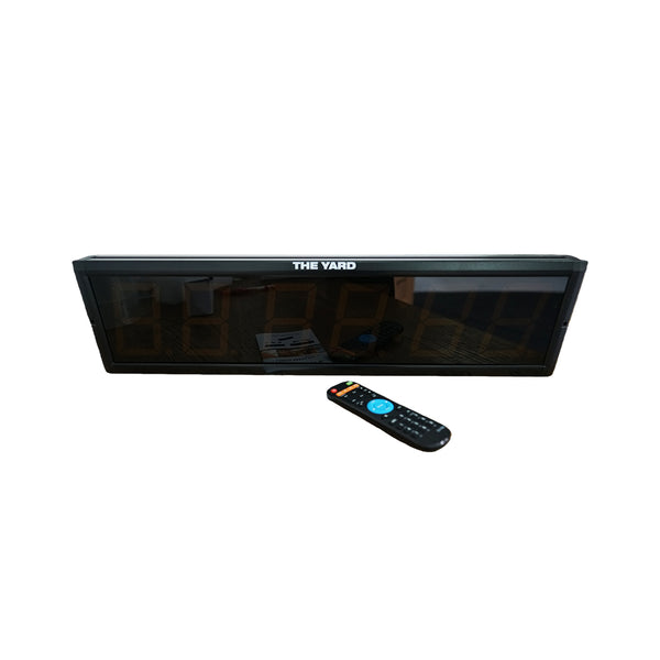 The SMAI The Yard - Cross Trainer Timer is a large digital wall clock shown with a remote control on a white background, featuring custom interval timer functions for versatile timing needs.