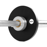 Close-up of SMAI Calibrated Weight Plates - 2.5kg (Pair) with a silver center ring on a barbell. The textured, knurled grip bar and bold SMAI logo highlight these durable, precision cast iron powerlifting plates.