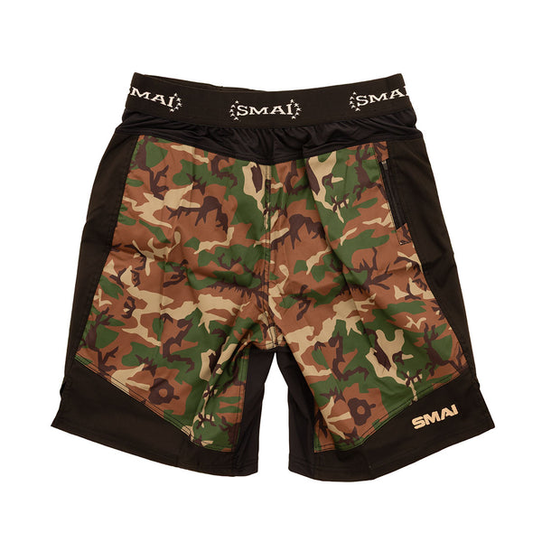 The SMAI Shorts - Cross Training Camo feature a green, brown, and tan camo design with black lycra panels for flexibility and "SMAI" branded in white on the waistband and lower left leg.