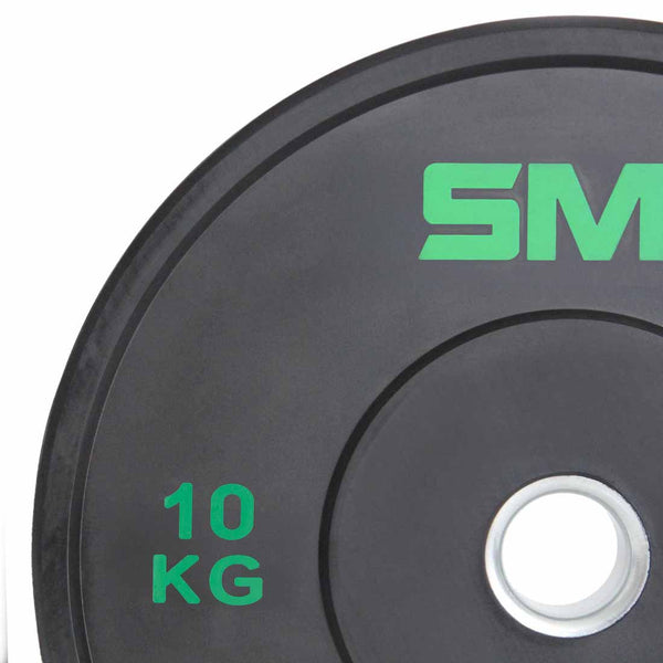 Close-up of a SMAI Home Gym Bumper Plate - 10kg with "10 KG" in green and part of the SMAI brand name on the upper right. The black bumper plate, ideal for home gyms, has a silver central hole.