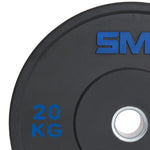 A close-up of an SMAI Home Gym Bumper Plate - 20kg (Pair) shows "20 KG" in blue and a blue logo with a silver center—an ideal choice from SMAI for home gym bumper plates.