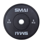 The SMAI Home Gym Bumper Plates - 5kg (Pair) feature a black design with "SMAI" and "5 KG" in white on both sides and a silver metal ring, making them perfect as Olympic or home gym bumper plates.