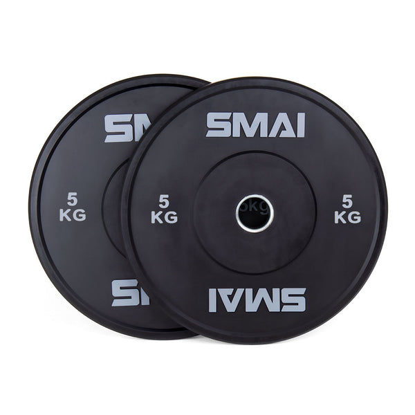 A pair of SMAI Home Gym Bumper Plates - 5kg, featuring sleek black design and clear SMAI branding, are stacked with one slightly overlapping the other against a white background—ideal for any home gym setup.
