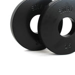 The SMAI Fractional Plate Pair 2.5kg comprises two black machined steel weight plates, one positioned slightly in front of the other. Each plate features the brand name "SMAI" and "2.5," and includes a central circular hole for convenient micro-loading onto a barbell.