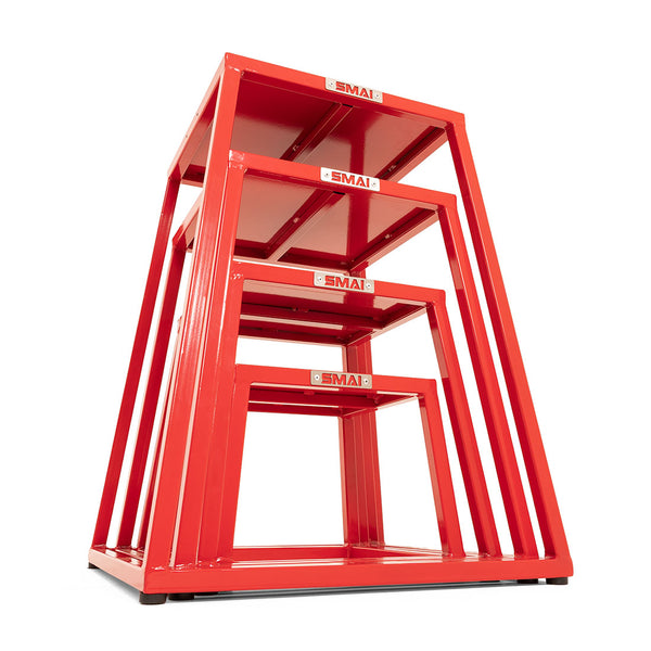 The SMAI Steel Plyo Box Set - 4 Pack Stackable includes four red metal boxes with open sides, rectangular tops, and a sturdy commercial-grade design. Each box nests inside the next for easy storage, ideal for intense plyometric workouts.