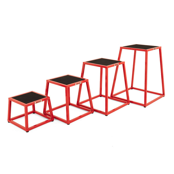 Four red SMAI Steel Plyo Box Set - 4 Pack Stackable plyometric boxes are lined up by increasing height. Each box has a black non-slip top and an open frame design for commercial use.