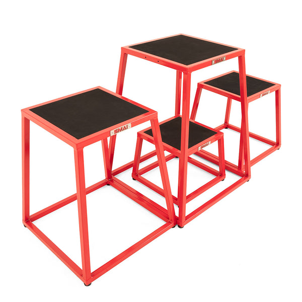 The SMAI Steel Plyo Box Set - 4 Pack Stackable features four red steel plyometric boxes of different heights with black non-slip tops, ideal for exercise and jump training.