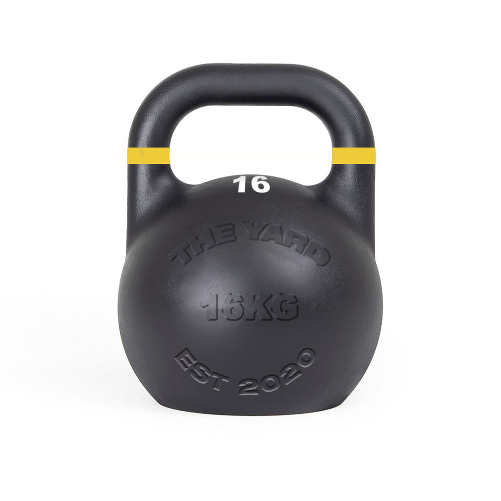 The SMAI The Yard - Competition Steel Kettlebell 16kg is black with a yellow stripe, labeled "16" and "16KG," and features "THE YARD" and "EST 2020" on the front. Consistent size design supports uniform training.