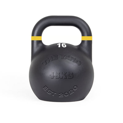 The SMAI The Yard - Competition Steel Kettlebell 16kg is black with a yellow stripe, labeled "16" and "16KG," and features "THE YARD" and "EST 2020" on the front. Consistent size design supports uniform training.