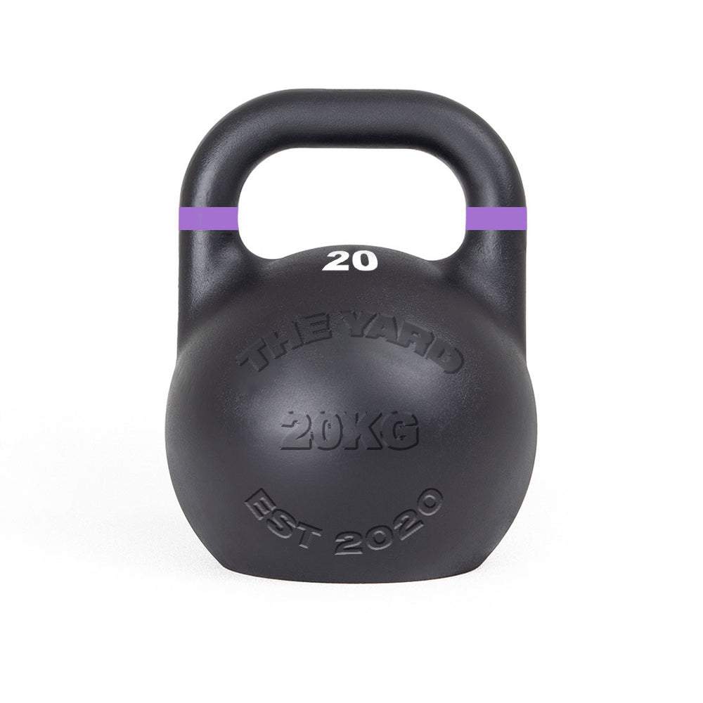 The SMAI The Yard - Competition Steel Kettlebell 20kg is a black kettlebell with a purple-striped handle, embossed with "THE YARD 20KG EST 2020," ideal for those wanting consistent size gym equipment.