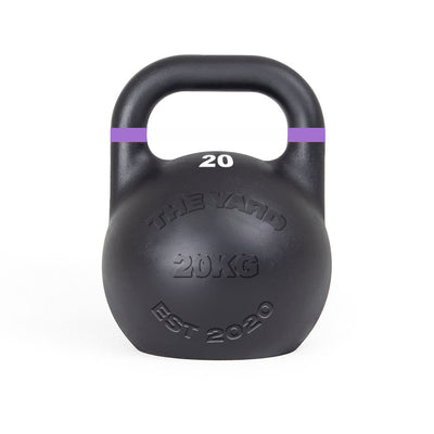 The SMAI The Yard - Competition Steel Kettlebell 20kg is a black kettlebell with a purple-striped handle, embossed with "THE YARD 20KG EST 2020," ideal for those wanting consistent size gym equipment.