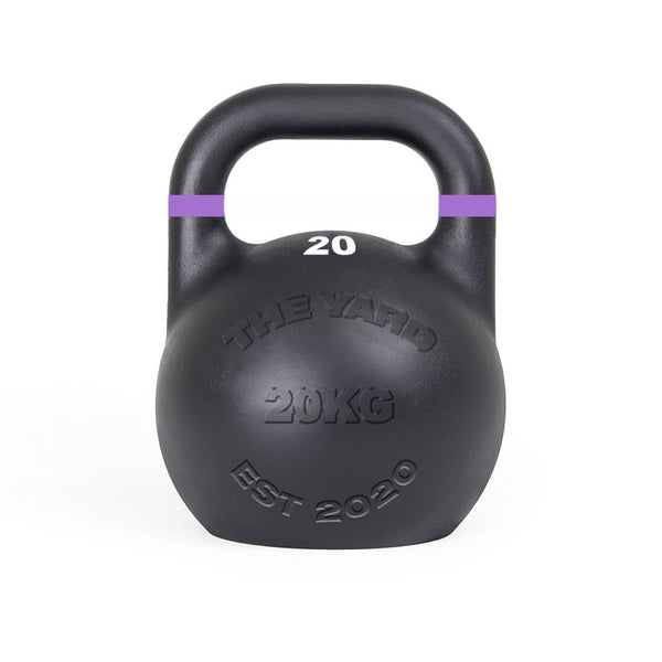 The SMAI The Yard - Competition Steel Kettlebell 20kg is a black kettlebell with a purple-striped handle, embossed with "THE YARD 20KG EST 2020," ideal for those wanting consistent size gym equipment.