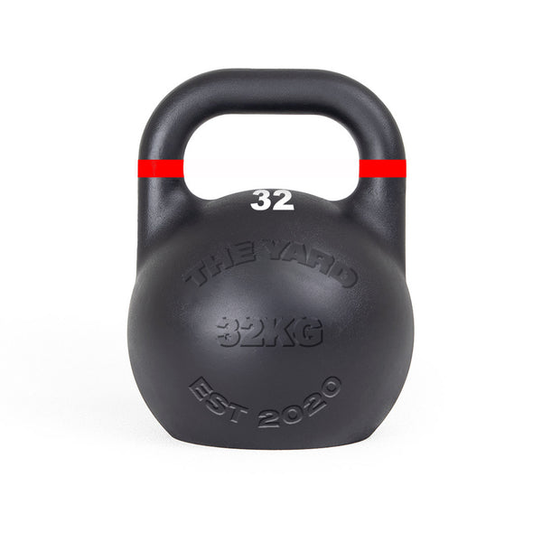 The SMAI The Yard - Competition Steel Kettlebell 32kg is black with a red stripe near the handle, features "THE YARD 32KG EST 2020" embossed on the front and "32" in white below the handle, and has a consistent size design.