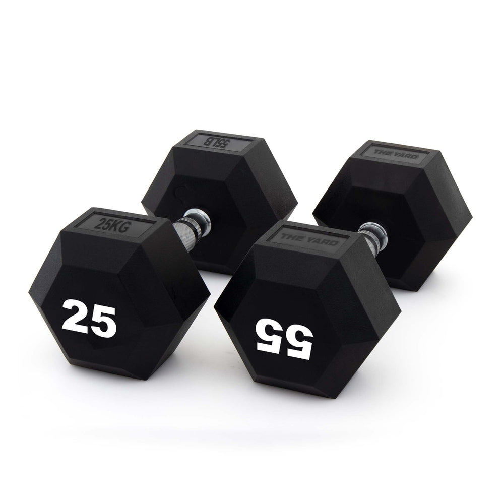 Two SMAI The Yard - Rubber Hex Dumbbell 25kg (Pair) are arranged on a white surface, showcasing their black hexagonal design and ergonomic metal grip handles.