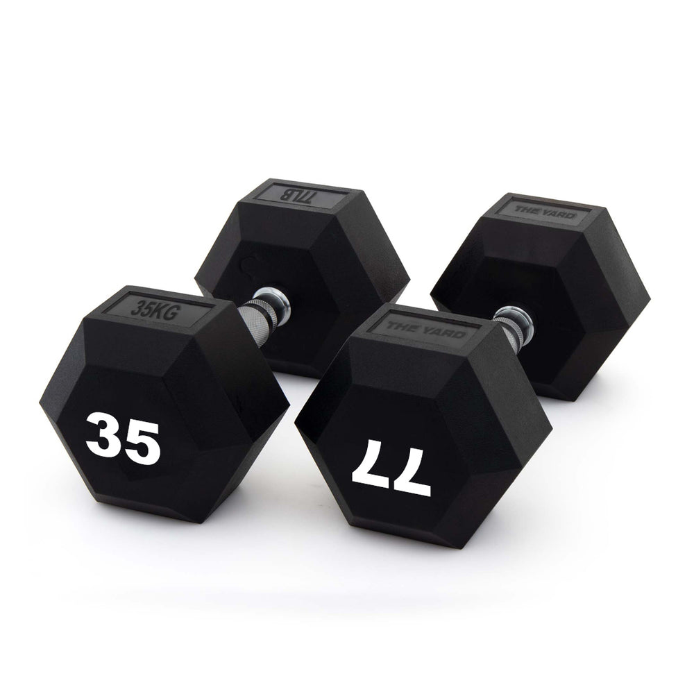 Three black hexagonal dumbbells, including the SMAI The Yard - Rubber Hex Dumbbell 35kg (Pair), are shown on a white background. The weights read “35KG,” “35,” and “11,” each with a metal handle and black rubber-coated ends—ideal for commercial gyms.