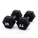 Three black hexagonal dumbbells, including the SMAI The Yard - Rubber Hex Dumbbell 35kg (Pair), are shown on a white background. The weights read “35KG,” “35,” and “11,” each with a metal handle and black rubber-coated ends—ideal for commercial gyms.