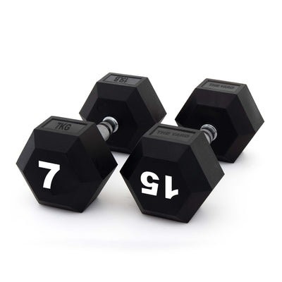 Three black SMAI The Yard - Rubber Hex Dumbbell 7kg pairs are arranged on a white surface, each marked "7 KG" in bold white numbers and designed with an ergonomic grip for comfortable commercial gym use.