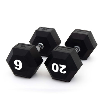 Three black SMAI The Yard - Rubber Hex Dumbbells with metal handles are arranged on a white background. Two commercial gym dumbbells display "9 KG" and "20 KG" in large white numbers on their ends.