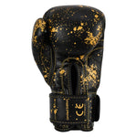 SMAI Essentials Kids Boxing Glove - Black/Gold Dragon, featuring black youth boxing gloves with a gold paint splatter pattern, gold stitching, and “Limited Edition” and “CE” printed on the wrist strap.