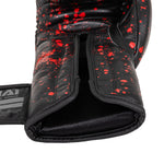 A close-up of the SMAI Boxing Glove - Black Dragon Limited Edition, featuring black injection moulding with red splatter design, an open wrist area, and a partially visible brand label on the left strap.