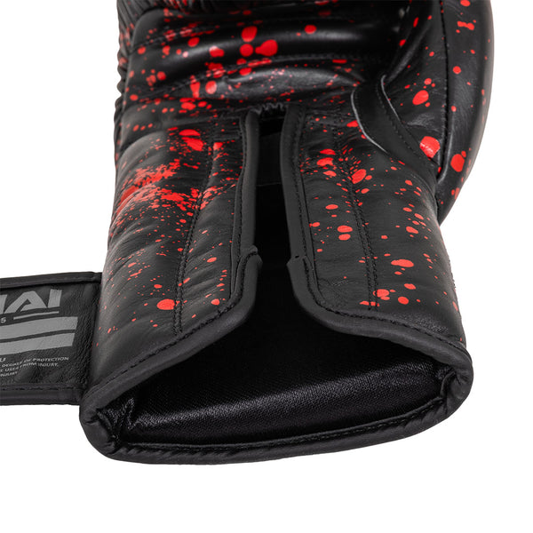A close-up of the SMAI Boxing Glove - Black Dragon Limited Edition, featuring black injection moulding with red splatter design, an open wrist area, and a partially visible brand label on the left strap.