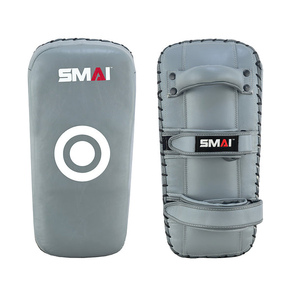 Two charcoal Elite85 Muay Thai Pads V2 by SMAI are pictured—one with a white target circle, the other with two grip handles and an arm strap. Both feature impact absorbing foam for optimal training sessions and display the SMAI logo at the top.