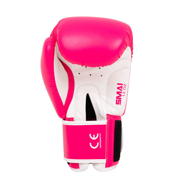 The Essentials Boxing Glove - Pink by SMAI is shown upright against a white background, featuring pink and white colors, a black Velcro strap, "SMAI 12oz" label, and CE certification mark.