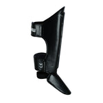 The SMAI Essentials Muay Thai Shin Guards Kids - Black offer adjustable straps and a textured surface, combining shin and instep protection—ideal sports gear for children training in martial arts or needing added sports protection.