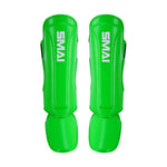 Essentials Muay Thai Shin Guards Kids in bright green by SMAI, shown on a white background—ideal protective sports gear for young athletes.