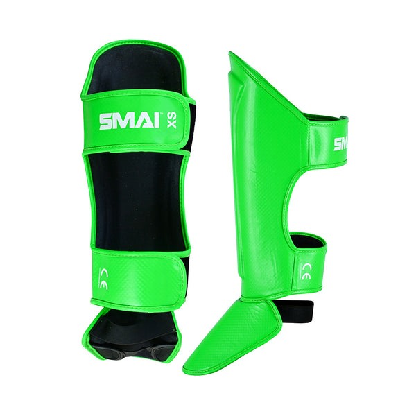 Essentials Muay Thai Shin Guards Kids - Green by SMAI, featuring black inner padding and adjustable straps, shown front and side on a white background—ideal protective gear for young athletes.