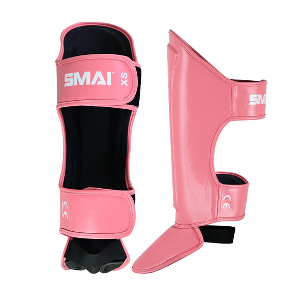 Essentials Muay Thai Shin Guards Kids - Pink by SMAI, size XS, shown front and side. Featuring black lining, adjustable straps, and durable shin protection—ideal children's gear.
