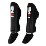 Introducing the Essentials Muay Thai Shin Guards - Kids by SMAI—a pair of black shin instep guards with attached foot protection, featuring the distinctive white and red “SMAI” logo on the front—ideal for protecting young martial artists.