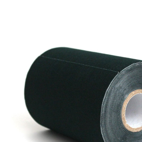 A close-up of a large, tightly rolled Turf Tape by SMAI in black, positioned horizontally. The edges are neatly aligned, and the inside of the roll is visible at the right end.