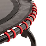 Close-up of the SMAI Folding Rebounder Mini Trampoline 45", highlighting the black frame and red elastic bands connecting the jumping mat—ideal as compact fitness equipment.