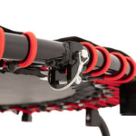 Close-up of the SMAI Folding Rebounder Mini Trampoline 45" showing its black metal frame, red bungee cords, and silver locking pin, with the foldable mat and legs visible in the background.