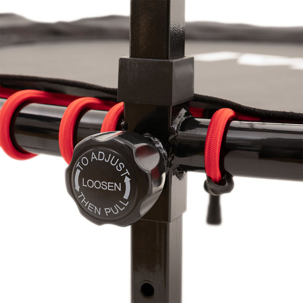 Close-up of the SMAI Folding Rebounder Mini Trampoline 45" frame with a black knob labeled "TO ADJUST LOOSEN THEN PULL" and red elastic cords, showcasing its durable fitness construction.