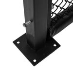 Close-up of an SMAI MMA Cage Wall - Single Panel featuring a black metal post with a bolt, connected to a reinforced cage mesh. It is mounted on a square base with four holes that rests on a flat surface. The panel includes black padding wrapped around part of the mesh, typical for an MMA cage setup.