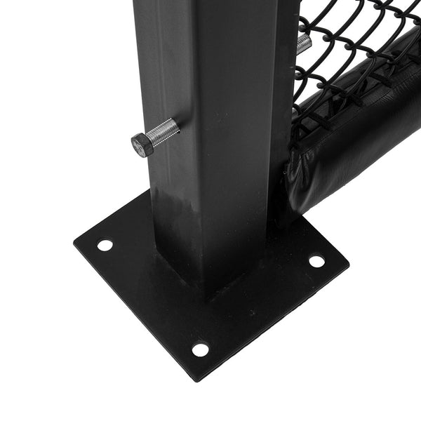 Close-up of an SMAI MMA Cage Wall - Single Panel featuring a black metal post with a bolt, connected to a reinforced cage mesh. It is mounted on a square base with four holes that rests on a flat surface. The panel includes black padding wrapped around part of the mesh, typical for an MMA cage setup.