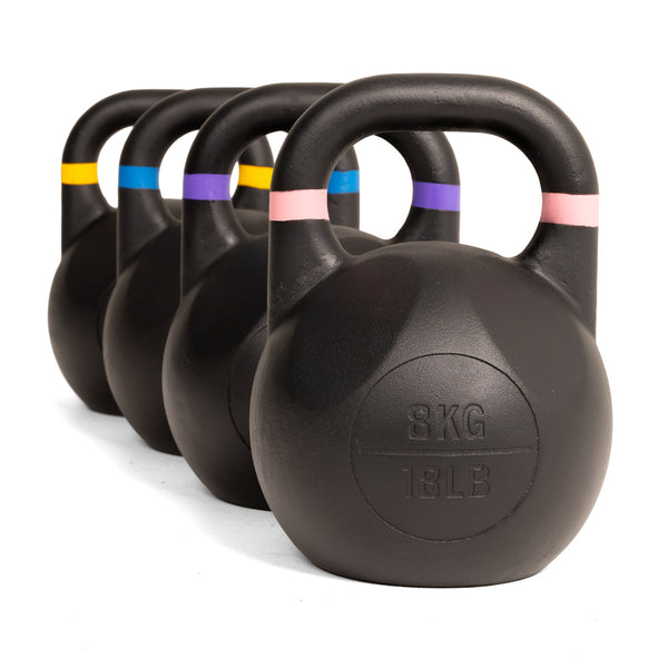 Four SMAI Competition Kettlebell - Fusion Series kettlebells, finished in black with colored bands on their handles, are arranged in a diagonal row. The nearest kettlebell is labeled 8KG / 18LB.