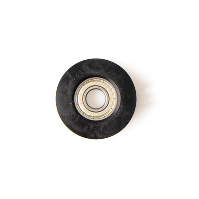 The SMAI Air Ski Machine Spare Part is a black plastic replacement bungee cord pulley with a metal ball bearing center, viewed from above on a white background.