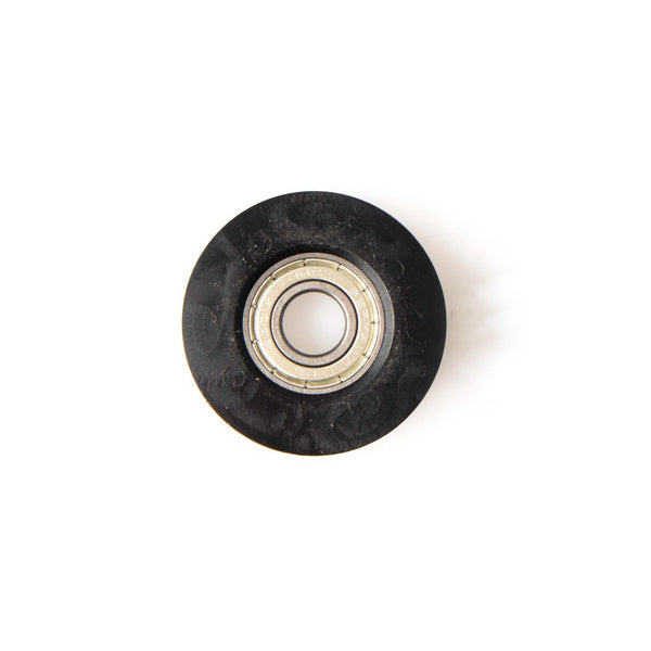 The SMAI Air Ski Machine Spare Part is a black plastic replacement bungee cord pulley with a metal ball bearing center, viewed from above on a white background.