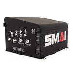 The SMAI Hip Thrust Box with Accessories is a black rectangular box labeled "SMAI," featuring white exercise icons, measurement markings, "GLUTE FOCUS BOX" text, a sloped top, and metal rings for resistance band workouts.