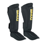 A pair of PRE ORDER - Gold Series Muay Thai Shin Guards in black/gold by SMAI, featuring yellow branding and multi-layered shock absorption for martial arts protection.